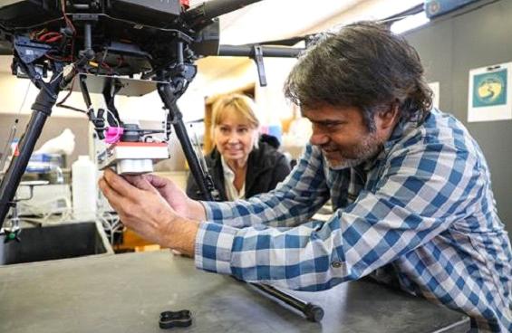 Professors work with a drone in a classroom